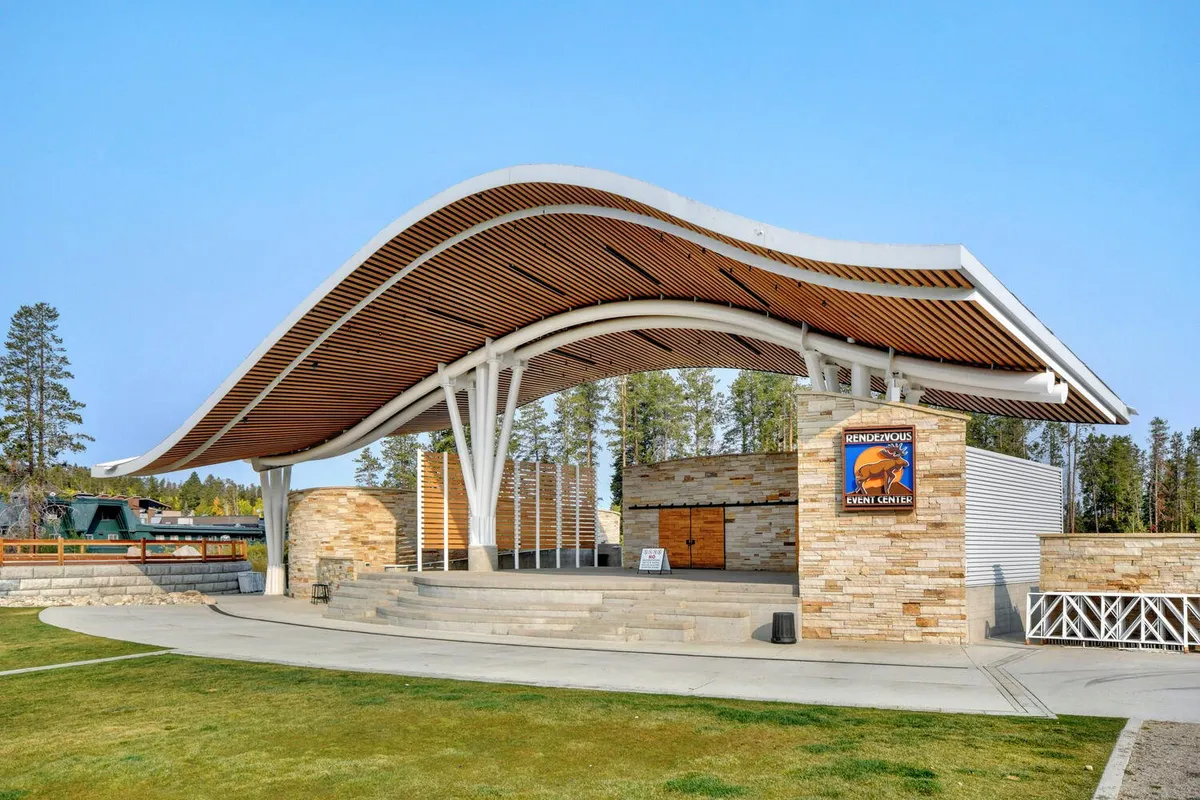 A vibrant shot of the Town Hideaway Park amphitheater, featuring a curved roof, stone facade, and event center signage. The photo hints at energetic community events, concerts, and social gatherings that bring the neighborhood to life.